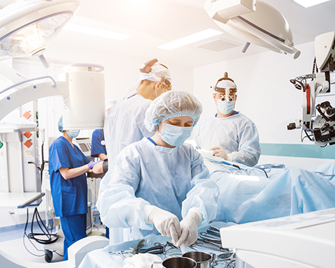 Gruppe von Chirurgen im Operationssaal mit Operationsausrüstung.