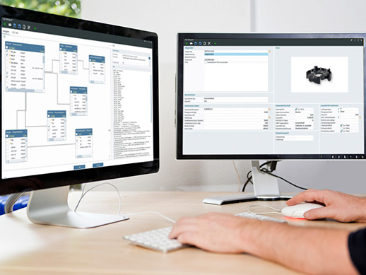 Zwei Computer-Monitore mit einem weißen Bildschirm auf einem Schreibtisch, mit den Händen eines Mannes auf einer Tastatur in einem Büro, für Mock-ups und Präsentationen geeignet, mit viel Kopie Platz für Ihr Design